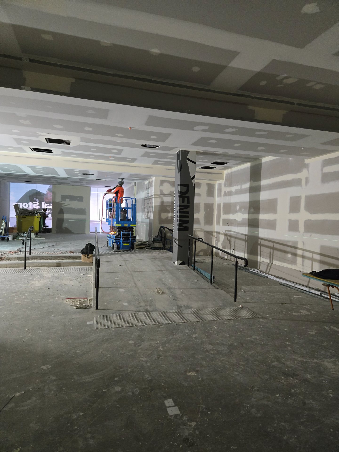 Commercial retail fit-out in progress with scissor lift
