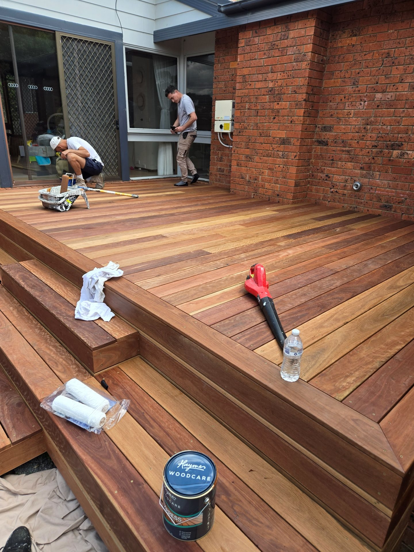 Freshly stained timber deck against a red brick home