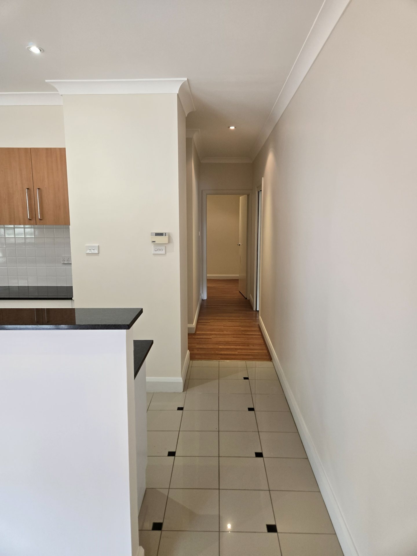 Freshly painted hallway leading to a kitchen with tiled floor