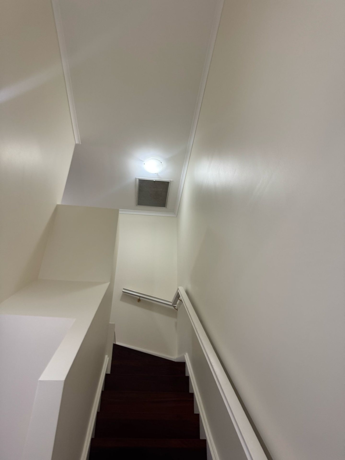 Freshly painted white stairwell with handrail