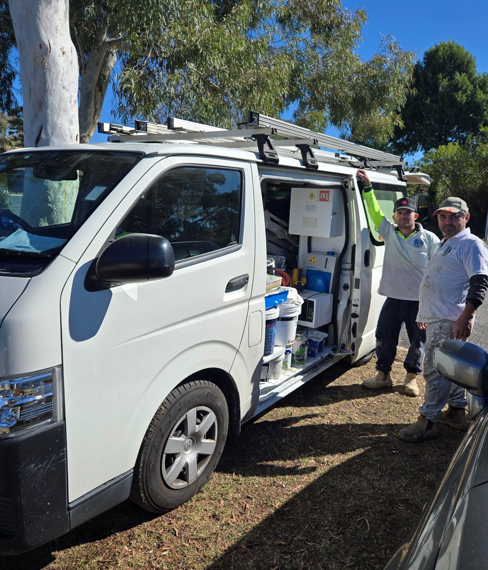 The Ainslie Painting Co. crew beside their fully stocked work van
